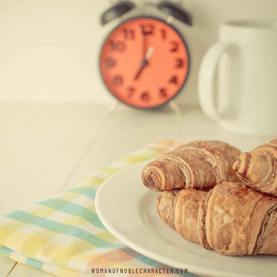 image of dish of croissants with coffee mug and clock for the post Don't Eat the Bread of Idleness and 5 Easy Ways to Rock Your To-Do List
