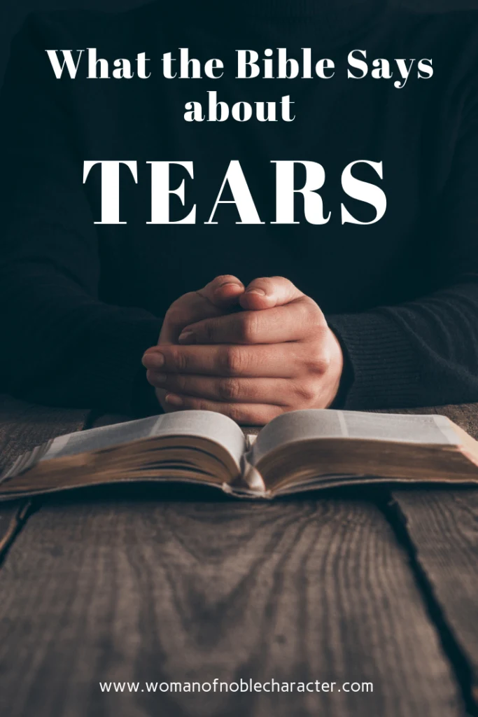 Picture of open Bible on table with folded hands near it with text what the Bible says about tears for post What the Bible says about tears