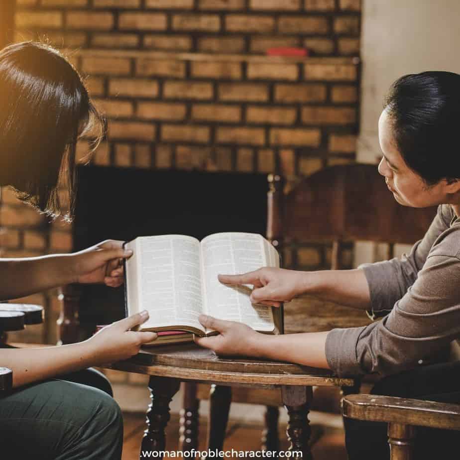image of woman pointing out something in Bible to another woman in living room for the post 4 Simple Illustrations for Sharing the Gospel