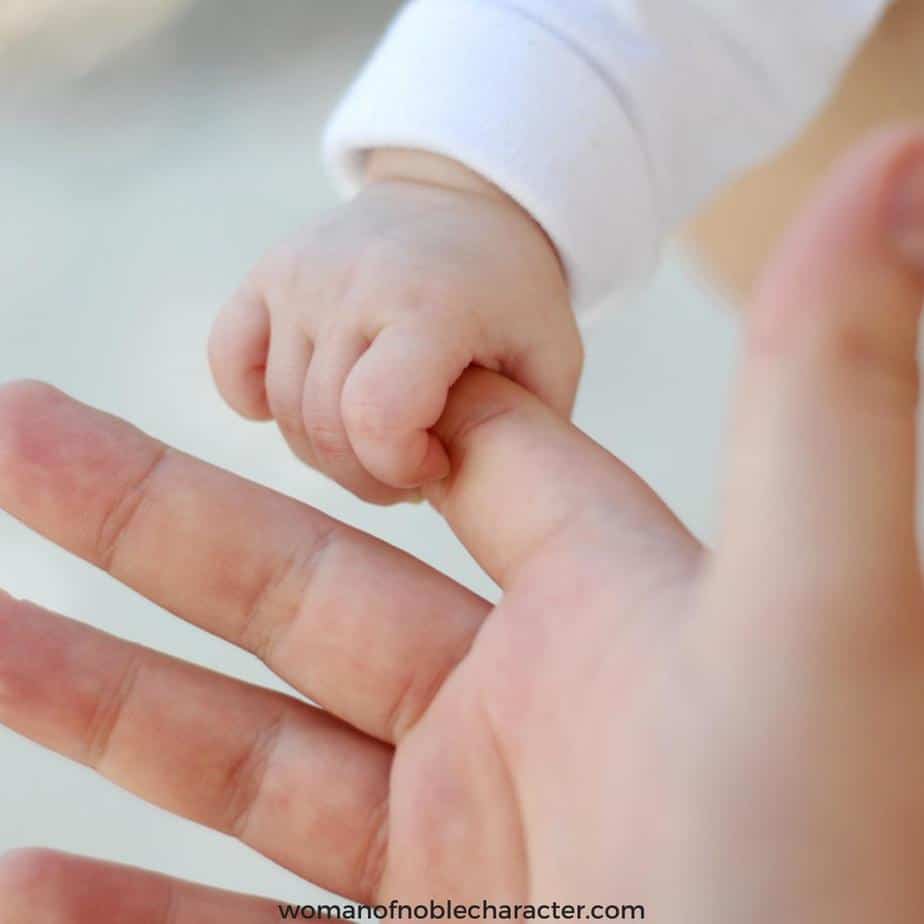 image of baby's hand grasping their mother's hand for the post My Adoption Story and God's Sovereign Hand in It