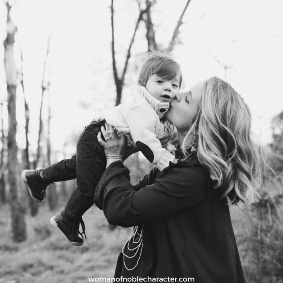 image of woman holding her toddler son up to kiss him for the post 10 Things I Learned Raising Sons