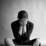 image of distraught woman sitting on floor with hands over face for the post Hope After Abortion: 6 Things An Abortion Taught Me About God