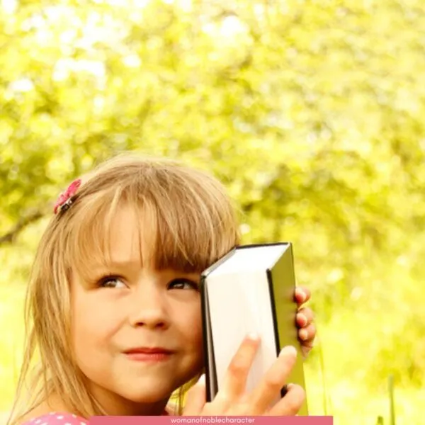 little girl hugging Bible for the post 25 Best Bible Verses for Children to Memorize