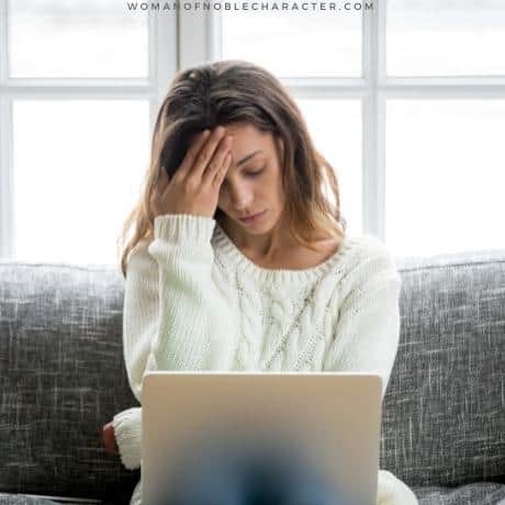 image of regretful woman sitting on couch with laptop and hand on head for the post What the Bible Says About Regret