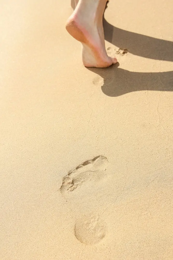 Beautiful footprints in the sand of the sea on a nature background; how to be closer to God