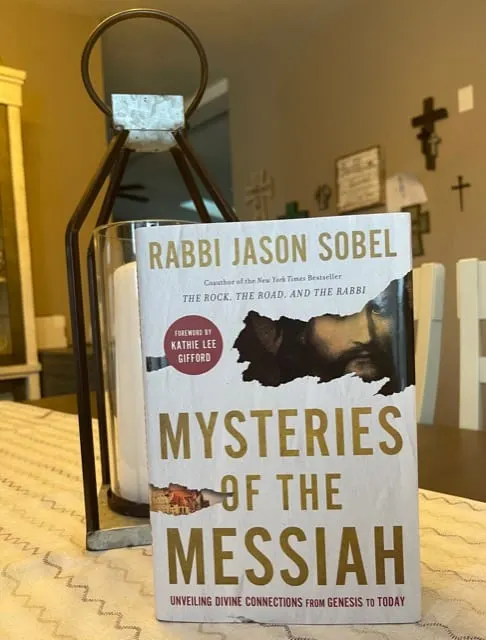 mysteries of the messiah book cover on table top with lantern