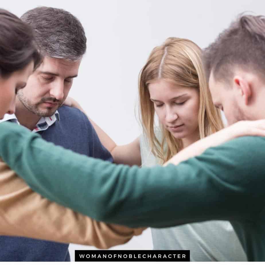 image of people in circle praying with hands on each other's shoulders for the post A Deeper Look at One Another in the Bible and Its 4 Major Themes