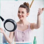 image of woman tossing pan in kitchen for the post A Look at Christian Homemaking and 7 Practical Tips