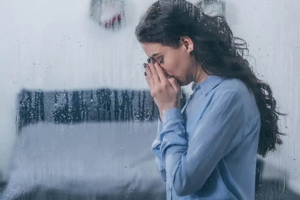 image of praying woman through window with rain for the post take thoughts captive