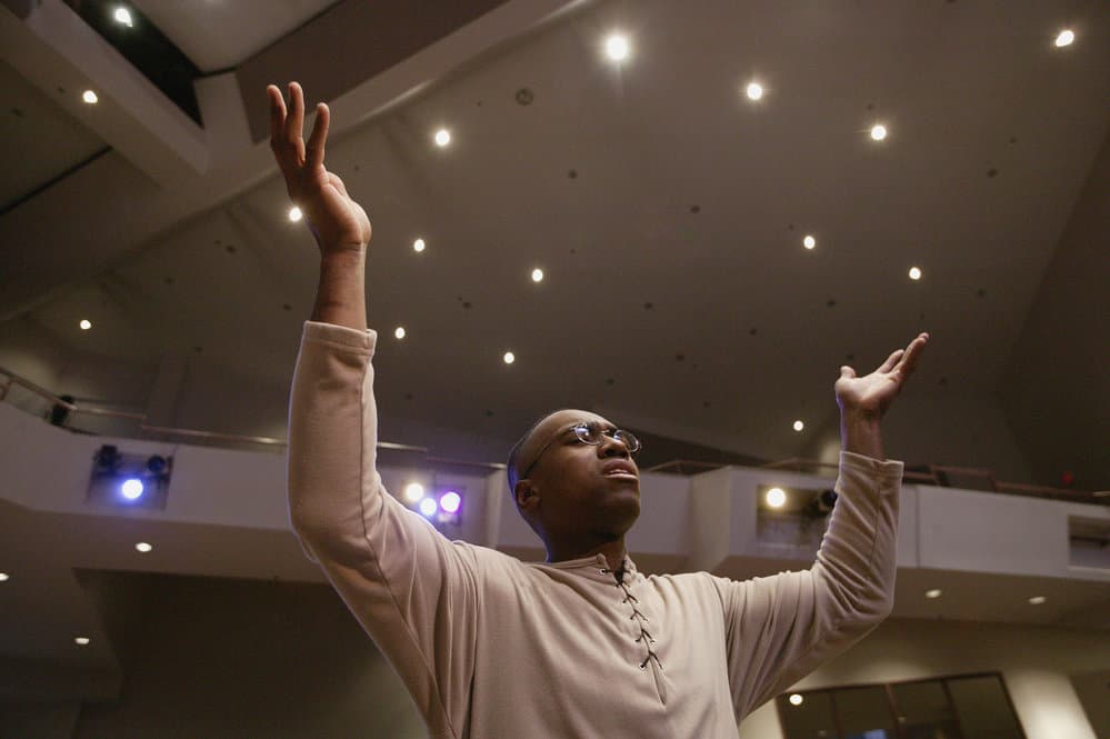 image of black man with hands held high for the post prayer for healing