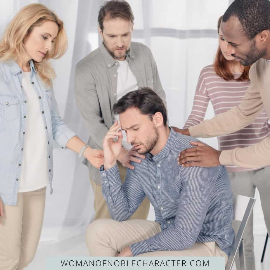 image of people laying hands on and praying for man with addiction for the post Prayer for Addiction: The Way Toward Healing and Redemption from Evil Desires