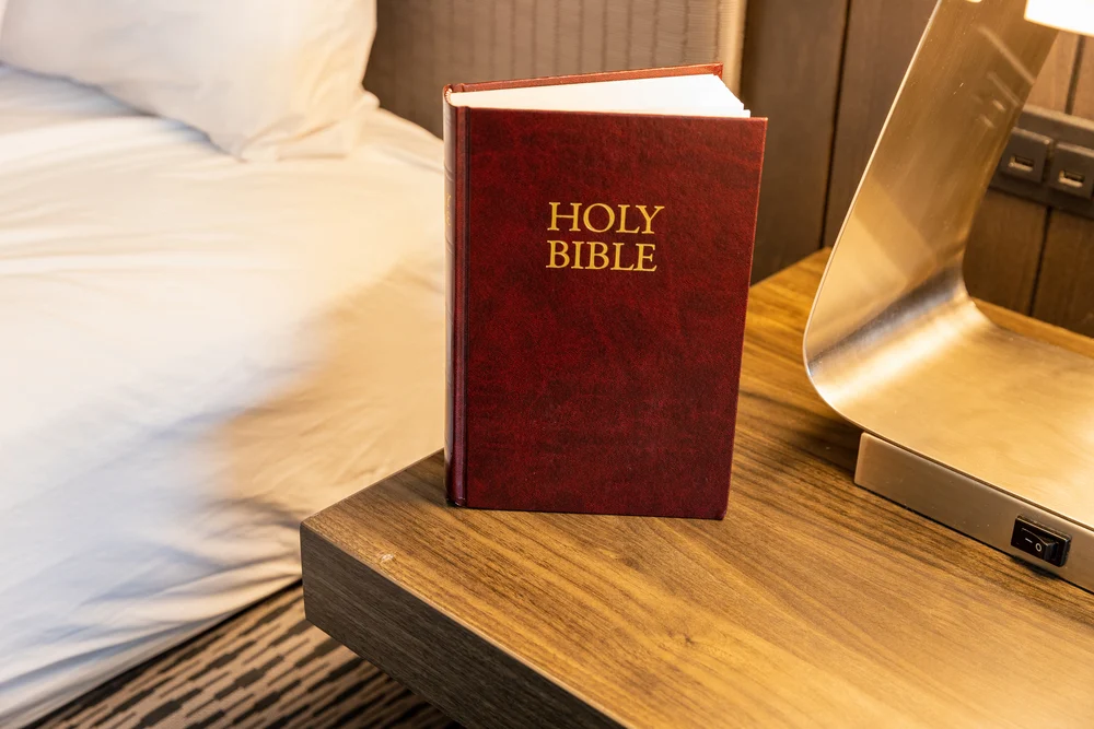 image of Bible in hotel room on bedside table for the post hospitality in the Bible and biblical hospitality