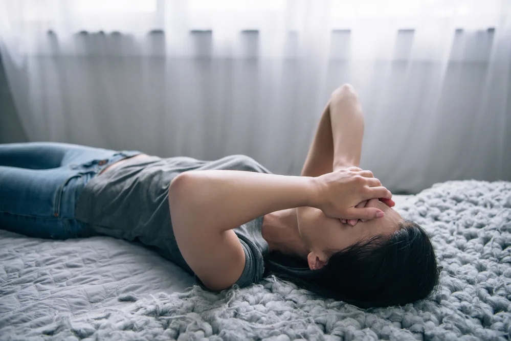 image of lonely woman laying on bed for the post on loneliness in the Bible