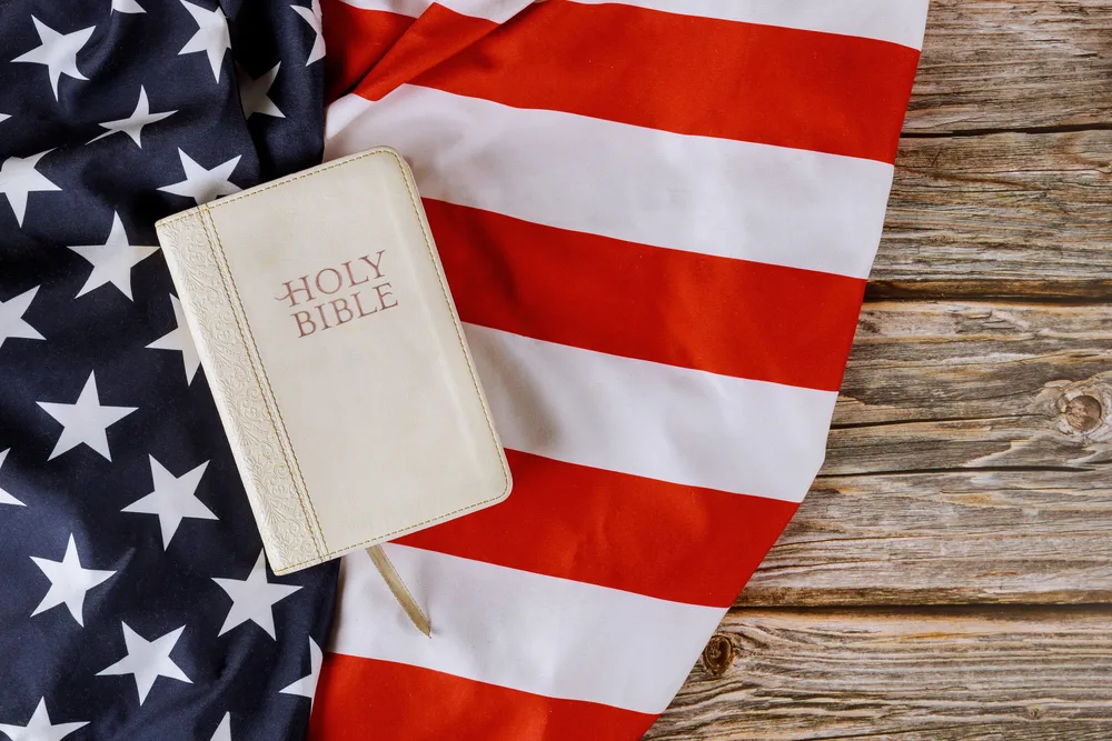 Prayer for america in Holy Bible over USA flag wood background for the post on prayer for the nation