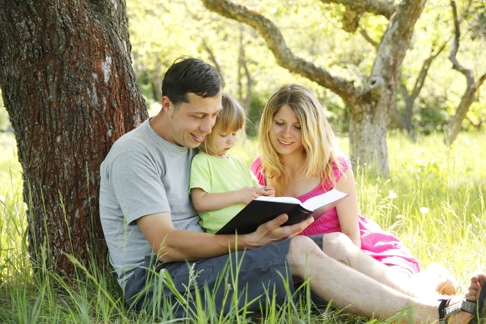 Young family reading the Bible in nature for the post balancing discipline and love in Christian parenting